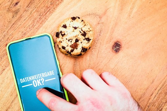 Cookies mit einem Tablet zur Verdeutlichung von Cookie Bannern für Websites mit auf deutsch Datenweitergabe ok? in Englisch Data transfer ok?