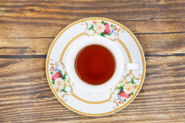 Cup of tea with macaroons on pink background