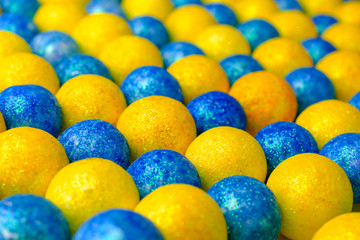 Many of bright blue and yellow balls lying in row diagonally. Multi Colored ball in colors of Ukrainian flag. Selective focus.