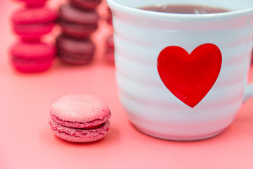 Cup of tea with Tasty Macaroon cookies  on pink background. closeup Assortment Almond Dessert macaroni.