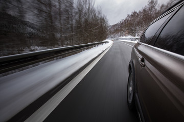 Obraz na płótnie Canvas Fast moving car on a winter alpine snowy road