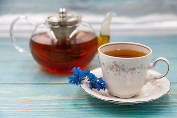 Cup of tea with macaroons on pink background
