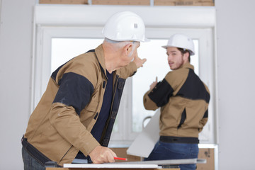 senior builder and young builder discussing a new project