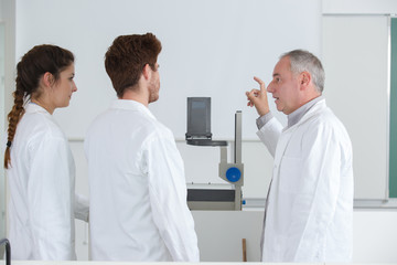 Obraz premium school boys with teacher in chemistry class