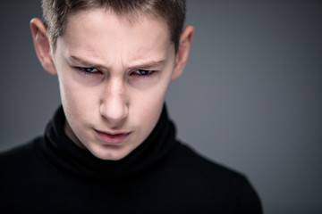 Loads of aggression in a little boy - education concept hinting behavioral problems in young children (shallow DOF) - little boy with hands clenched into fists about to punch someone