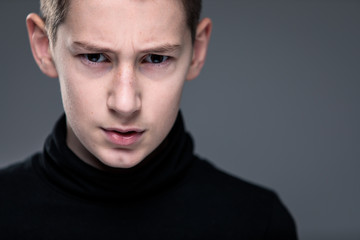 Fototapeta premium Loads of aggression in a little boy - education concept hinting behavioral problems in young children (shallow DOF) - little boy with hands clenched into fists about to punch someone