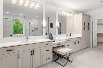 Bathroom in luxury home with double vanity, two mirrors, two sinks, and tile floor