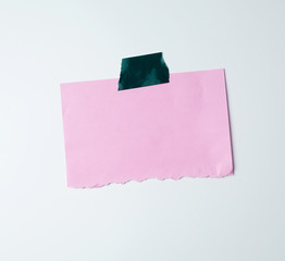 blank pink sheet of paper stuck with green sticky tape