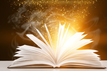 Open book with light fantasy illustration on table