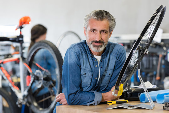 Portrait Of Smiling Man Working In Bike Rental Shop