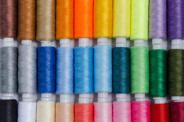 sewing threads different colors, very colorful in background, colorful background