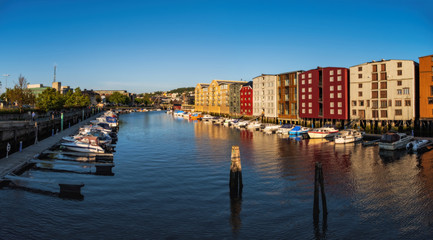 Obraz premium TRONDHEIM, NORWAY - july, 2019: Colorful old houses at the Nidelva river embankment in Trondheim, Norway.