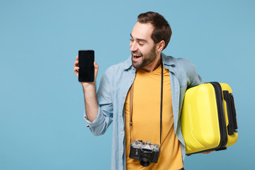 Cheerful traveler tourist man in summer clothes with photo camera isolated on blue background....