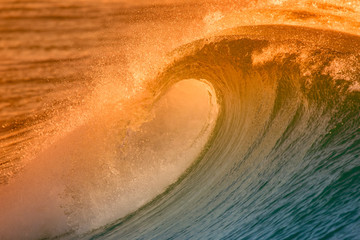 Beautiful big ocean wave with sunset color