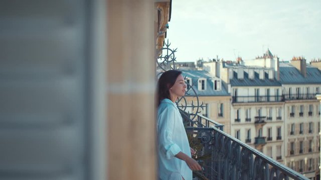 Young girl in a white shirt on a balcony in Paris