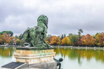 Fototapeta premium lion statue on the terrace in the Monument to Alfonso XII near the pond in the The Buen Retiro Park.