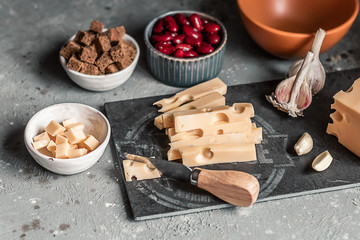 Healthy food: a source of healthy nutrition on a concrete gray background. Ingredients for cooking: red beans, hard cheese, crackers, brown bread, garlic.