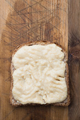 Slice of toast bread with hummus spread