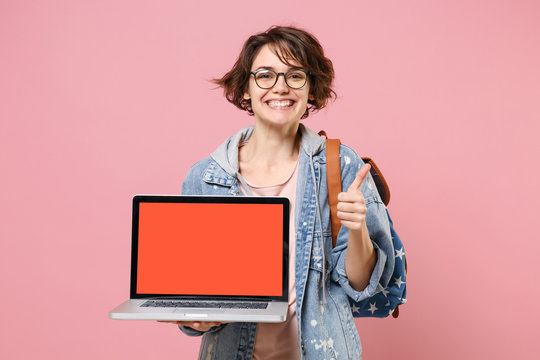 Smiling Girl Student In Denim Clothes Glasses Backpack Isolated On Pink Background. Education In High School University College Concept. Hold Laptop Computer With Blank Empty Screen Showing Thumb Up.