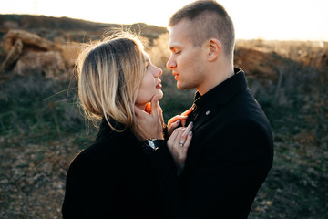 Side view portrait of two young lovers kissing on the sunset