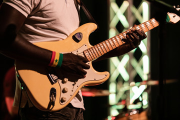 Closeup of african professional male musician wearing white t-shirt and playing electric guitar on...