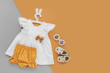 White dress,  orange shorts with kids shoes and sunglasses. Set of  baby clothes and accessories for spring or summer . Fashion childs outfit. Flat lay, top view