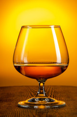 glass of Calvados Brandy and red apples on wooden table