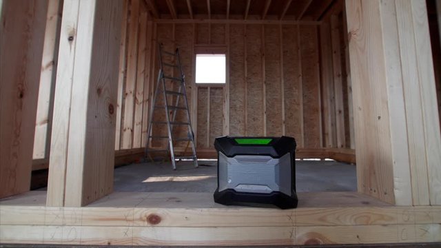 Modern radio transistor in unfinished wooden frame house. A man is pressing a button to listen to music