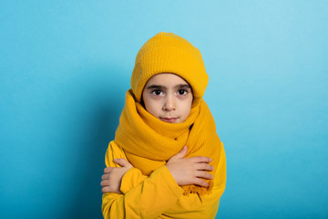 Child covers herself to avoid catching a cold. Cyan background