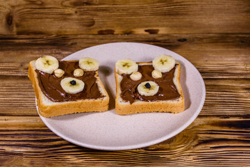Obraz na płótnie Canvas Two sandwiches with chocolate spread on a plate. Sandwich like a bear muzzle