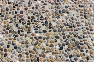 Stone wall texture, road made of small round and sea stones