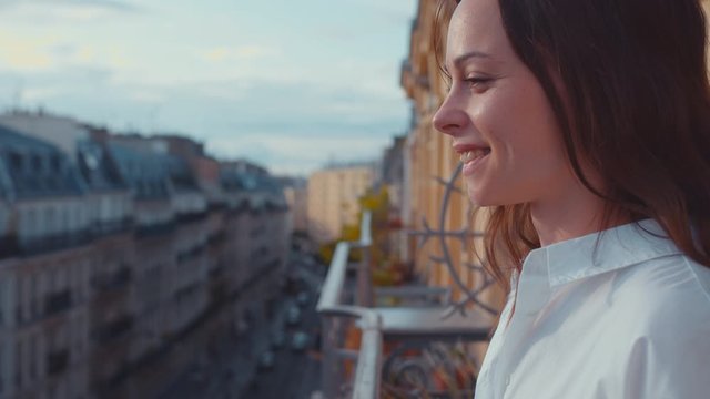 Smiling girl on the balcony in France, close-up