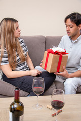 Cute young latin couple exchanging gift for valentines day