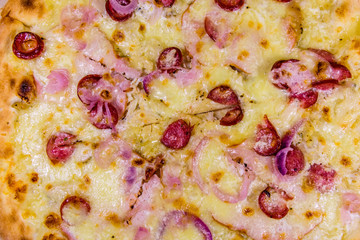 Background of the pizza with sausages, ham and parmesan cheese