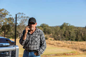 Man on mobile phone next to truck with antennas
