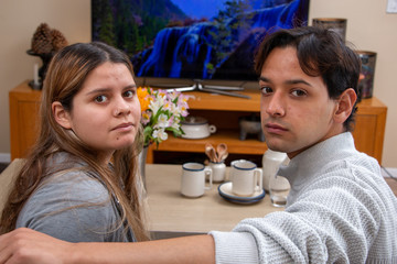 Nice ethnic couple watching TV at home