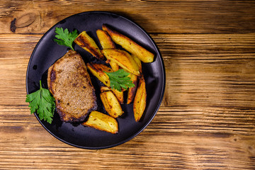 Roasted beefsteak with the fried potato and parsley. Top view