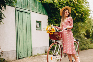 Happy woman with retro bike walking near shed