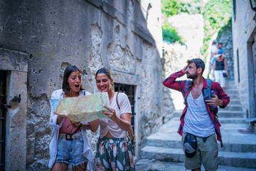 Young friends in old town using map