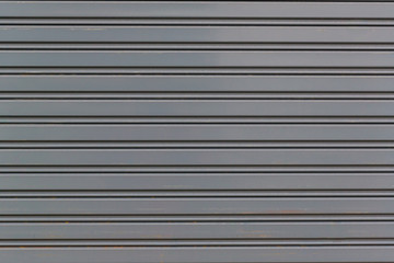 Metallic roll up door. Old Steel rolling shutter background. Metal security shutters protecting a...
