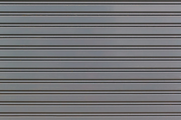 Fototapeta premium Metallic roll up door. Old Steel rolling shutter background. Metal security shutters protecting a small shop.