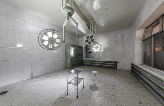 Operating theater with hanging shadowless light in an abandoned hospital.