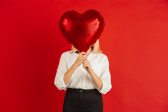 Heart-shaped Balloon. Valentine's Day Celebration, Happy, Cute Caucasian Kids Isolated On Red Studio Background. Concept Of Human Emotions, Facial Expression, Love, Relations, Romantic Holidays.