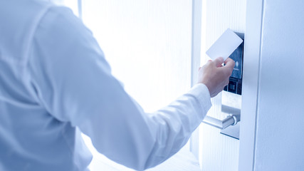 Hand holding key card using electronic card for access hotel room.