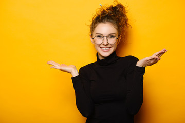 Pretty teenage girl with happy face on yellow background
