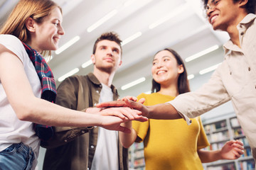 University Students put their hands together. Concept of teamwork and partnership