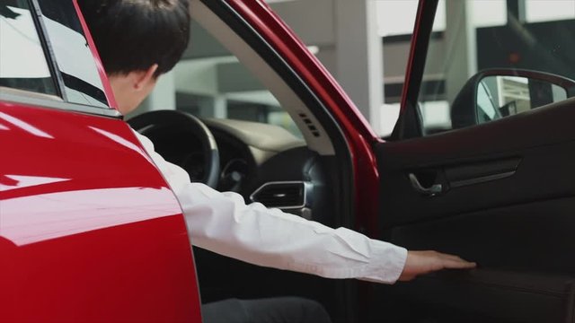BANGSAN THAILAND JAN 2020 Asian man saleman walking to drive to open Car door in dealership so Testdrive for customers.to automotive automobile or transport transportation for Illustrative editorial v