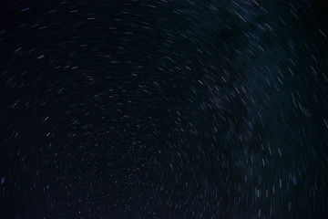 Astro Photography. Background Of Stars Traces Revolving Around The North Pole By Circular Trails Against Night Black Sky.