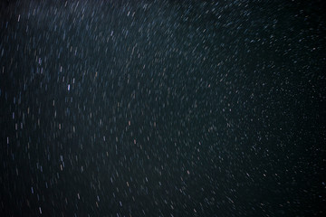 Astro Photography. Background Of Stars Traces Revolving Around The North Pole By Circular Trails Against Night Black Sky
