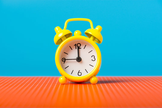 Time management concept. Yellow alarm clock on the desk